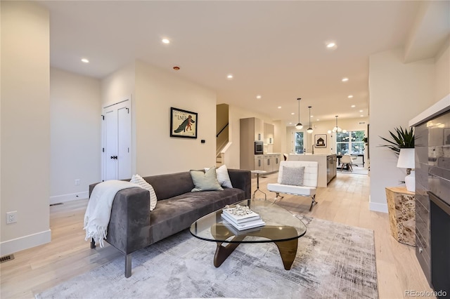2466 S Cherokee St, Denver, CO 80223 - living room featuring stairs, light wood-style flooring, and recessed lighting