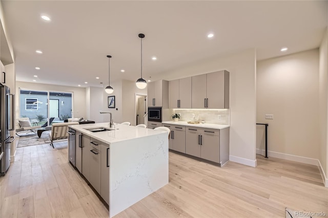 2466 S Cherokee St, Denver, CO 80223 - kitchen featuring gray cabinets, light wood finished floors, backsplash, black microwave, and recessed lighting
