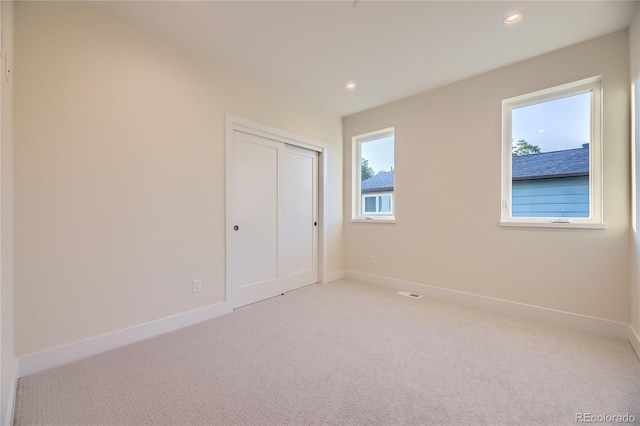 2466 S Cherokee St, Denver, CO 80223 - unfurnished bedroom featuring light colored carpet, multiple windows, recessed lighting, and a closet