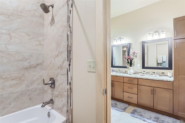 bathroom featuring tiled shower / bath, vanity, and tile patterned flooring