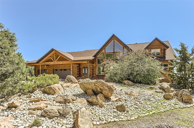 log-style house with log exterior and an attached garage