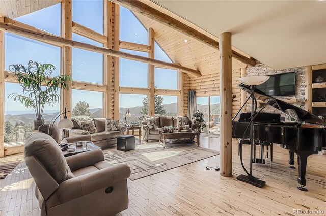 living room with light wood-type flooring, high vaulted ceiling, and beam ceiling