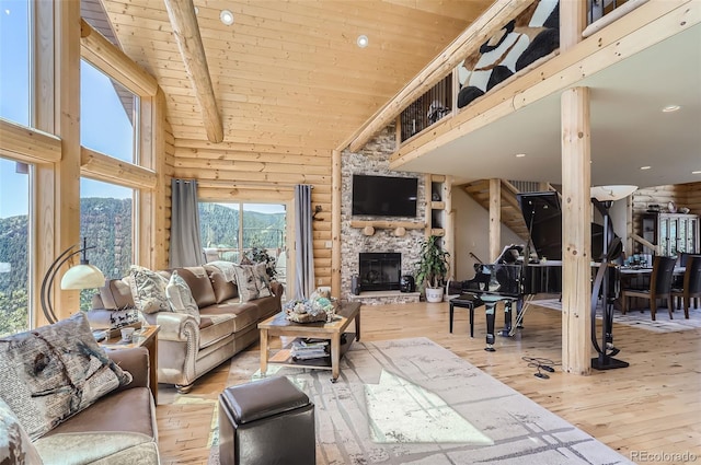 living room with a fireplace, high vaulted ceiling, beam ceiling, and light hardwood / wood-style floors