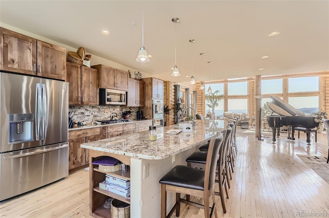 kitchen with open shelves, tasteful backsplash, appliances with stainless steel finishes, light wood-style floors, and a sink