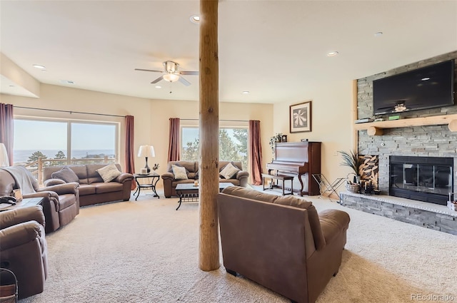 carpeted living room featuring recessed lighting, ceiling fan, and a stone fireplace