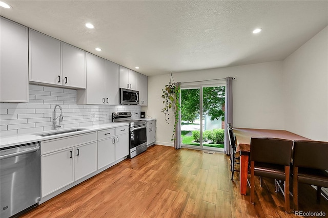 6765 S Independence St, Littleton, CO 80128 - kitchen featuring stainless steel appliances, a sink, light wood-style flooring, light countertops, and recessed lighting