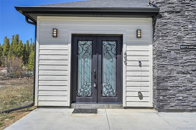 499 Silver Creek Rd, Idaho Springs, CO 80452 - doorway to property featuring french doors, roof with shingles, and stone siding