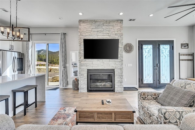 499 Silver Creek Rd, Idaho Springs, CO 80452 - living room featuring wood finished floors, a chandelier, recessed lighting, ceiling fan, and a fireplace