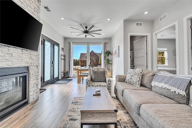 499 Silver Creek Rd, Idaho Springs, CO 80452 - living room with light wood finished floors, a ceiling fan, a stone fireplace, recessed lighting, and french doors