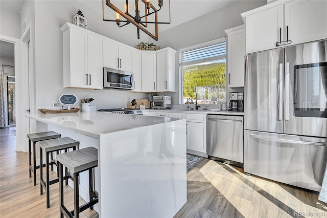 499 Silver Creek Rd, Idaho Springs, CO 80452 - kitchen with appliances with stainless steel finishes, a breakfast bar area, a chandelier, and white cabinetry