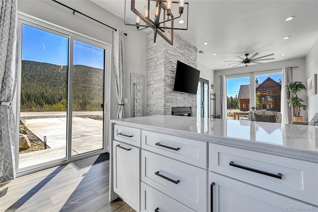 499 Silver Creek Rd, Idaho Springs, CO 80452 - kitchen with light stone countertops, white cabinets, recessed lighting, a chandelier, and open floor plan