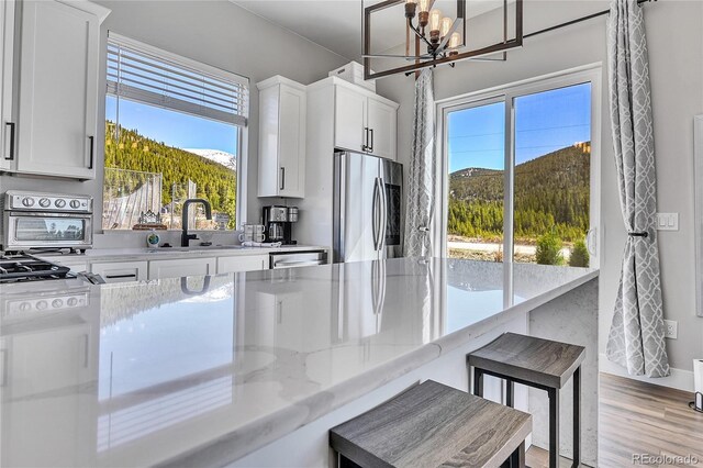 499 Silver Creek Rd, Idaho Springs, CO 80452 - kitchen featuring freestanding refrigerator, a sink, a chandelier, and plenty of natural light