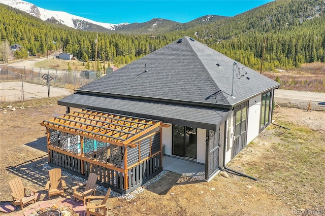 499 Silver Creek Rd, Idaho Springs, CO 80452 - back of house featuring roof with shingles, an outdoor fire pit, a mountain view, and a view of trees
