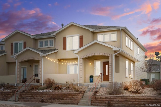 view of front of property with stucco siding and a shingled roof