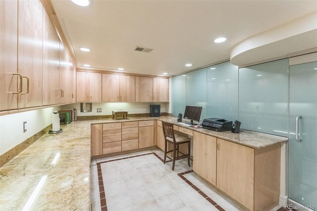 461 Fillmore St, Denver, CO 80206 - kitchen with light brown cabinetry, built in desk, light stone countertops, recessed lighting, and inlaid floor details