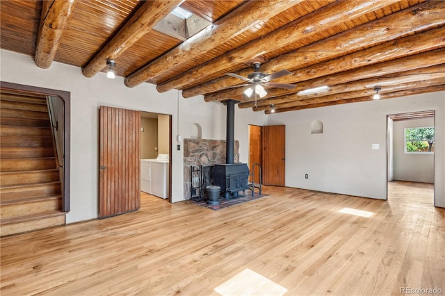 13 Crystal Park Rd, Manitou Springs, CO 80829 - unfurnished living room with washer and clothes dryer, a wood stove, light wood finished floors, a wooden ceiling with exposed beams, and stairway