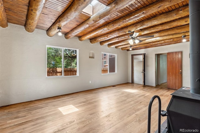 13 Crystal Park Rd, Manitou Springs, CO 80829 - unfurnished living room featuring a wood ceiling with exposed beams, light wood-type flooring, a ceiling fan, and a wood stove