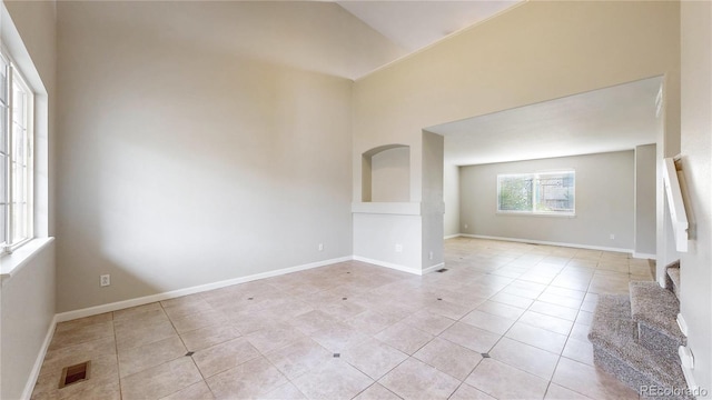 unfurnished room featuring light tile patterned floors, visible vents, and baseboards