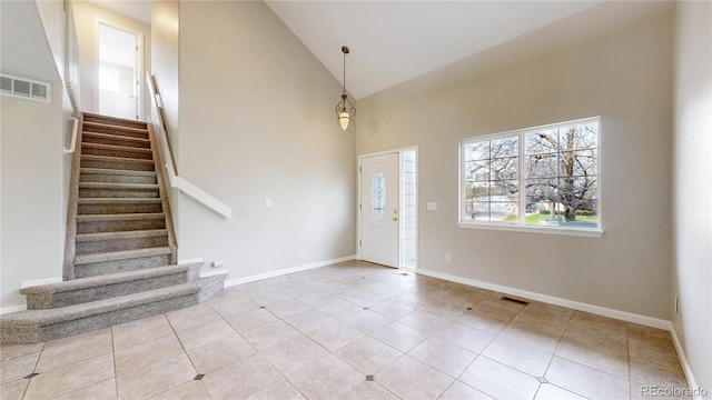 foyer entrance featuring stairway, high vaulted ceiling, visible vents, and tile patterned floors