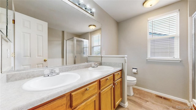 bathroom with toilet, visible vents, a stall shower, and a sink