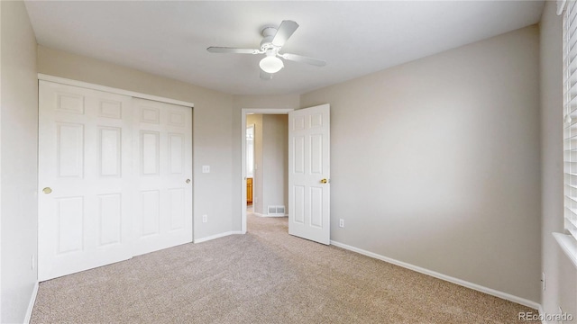 unfurnished bedroom featuring a closet, baseboards, carpet flooring, ceiling fan, and visible vents