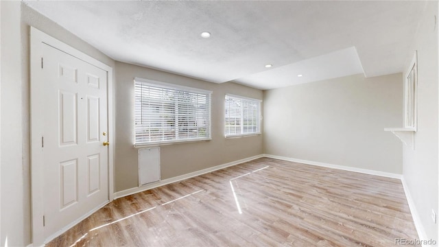 spare room featuring wood finished floors, baseboards, and recessed lighting