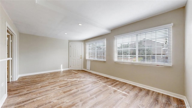 empty room with baseboards, recessed lighting, and wood finished floors