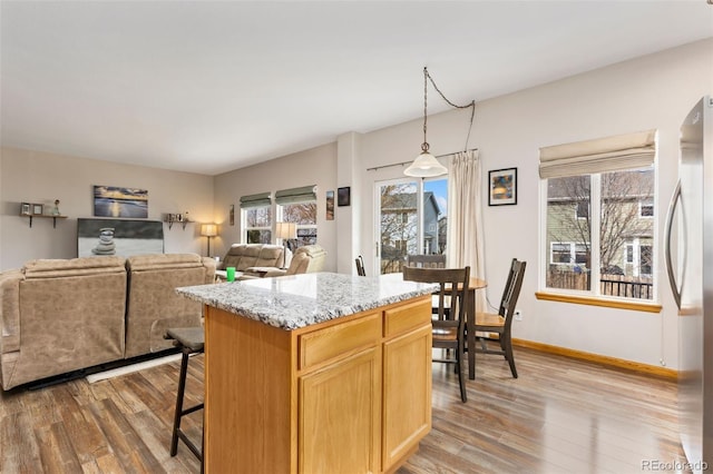 kitchen with freestanding refrigerator, light wood-style floors, a kitchen island, and open floor plan