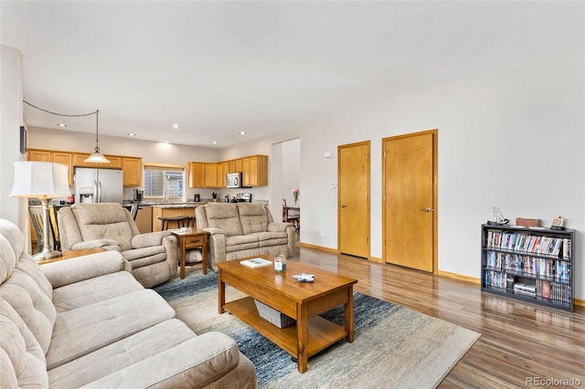 living area with light wood-style flooring, recessed lighting, and baseboards