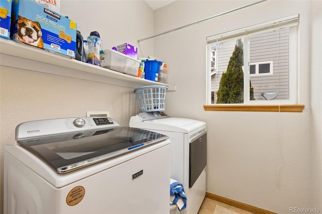 clothes washing area featuring independent washer and dryer and baseboards