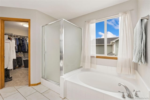 bathroom featuring a stall shower, a walk in closet, a garden tub, and tile patterned floors