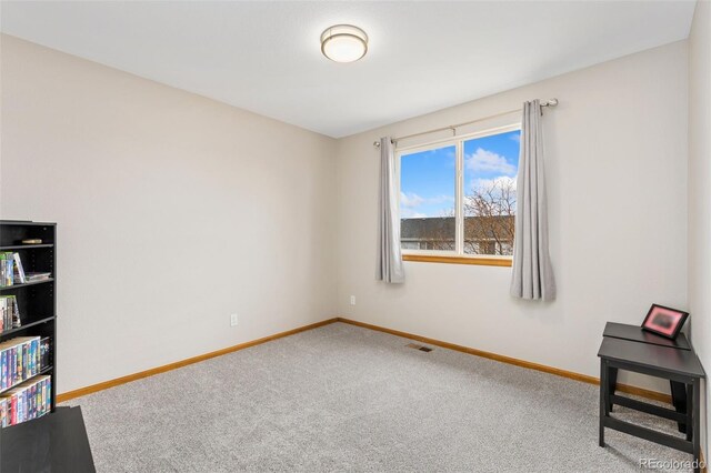 carpeted spare room featuring baseboards