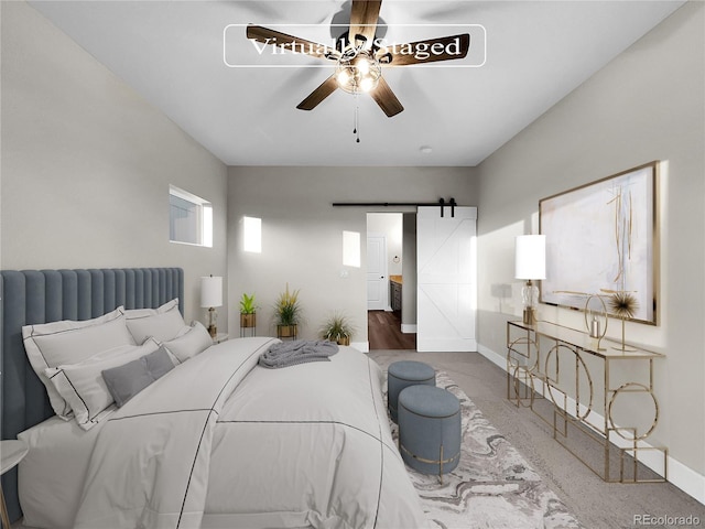 bedroom with a barn door, ceiling fan, and wood-type flooring