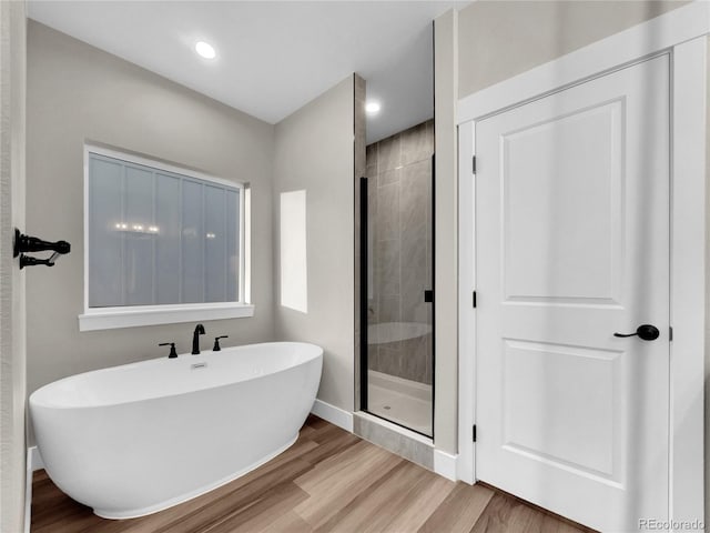 bathroom featuring separate shower and tub and wood-type flooring