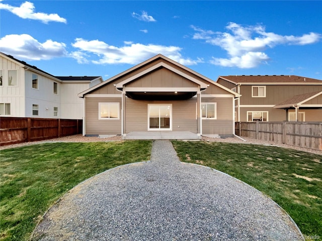 back of property with a yard and a patio