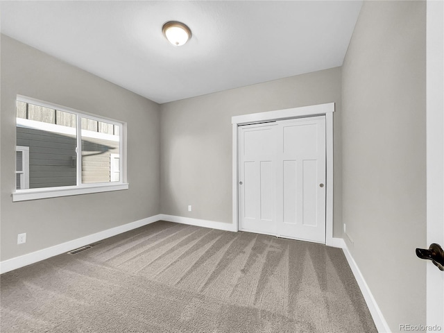 unfurnished bedroom with carpet flooring and a closet