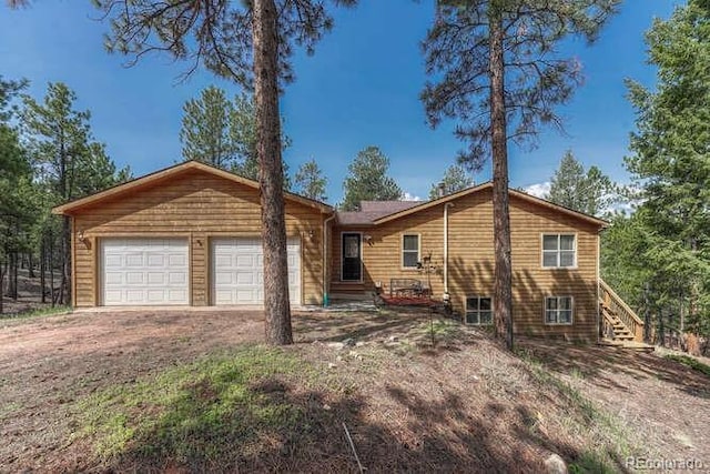 14694 Crooked Trail Rd, Woodland Park, CO 80863 - view of front of house featuring driveway, a garage, and stairs