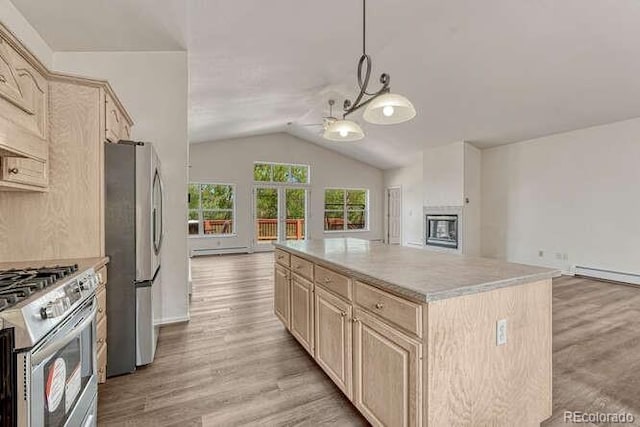 14694 Crooked Trail Rd, Woodland Park, CO 80863 - kitchen featuring appliances with stainless steel finishes, light brown cabinets, open floor plan, vaulted ceiling, and light wood-type flooring