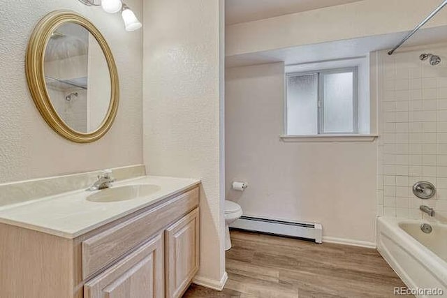 14694 Crooked Trail Rd, Woodland Park, CO 80863 - bathroom featuring a baseboard heating unit, vanity, toilet, wood finished floors, and shower / bathtub combination