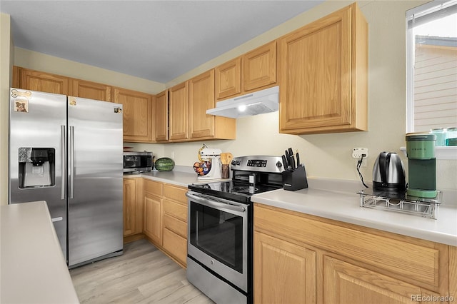 12585 S Beaver Creek Way, Parker, CO 80134 - kitchen with appliances with stainless steel finishes, under cabinet range hood, light countertops, light wood-style flooring, and light brown cabinetry