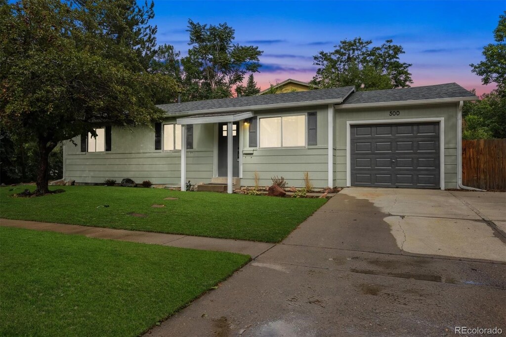 ranch-style house with a yard and a garage