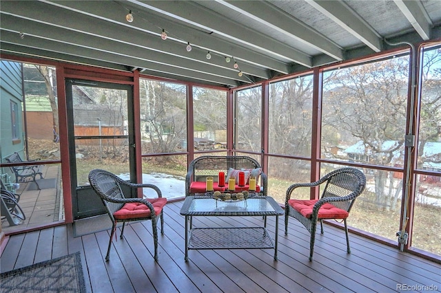 sunroom / solarium featuring beam ceiling