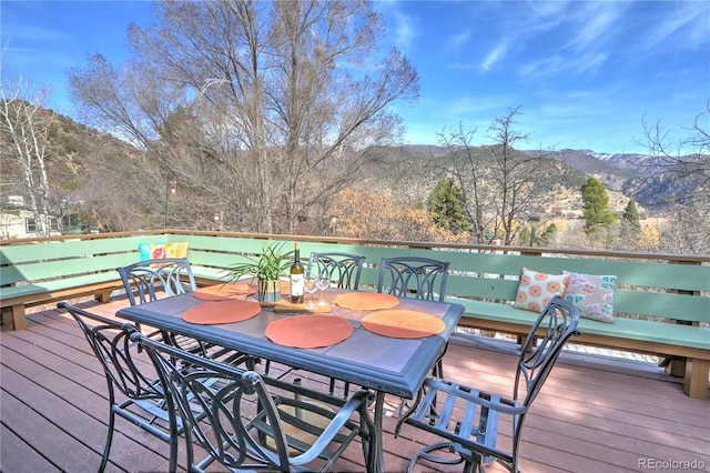 wooden terrace with a mountain view and outdoor dining area