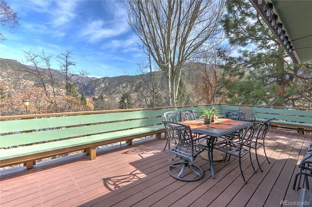 wooden deck featuring a mountain view and outdoor dining area