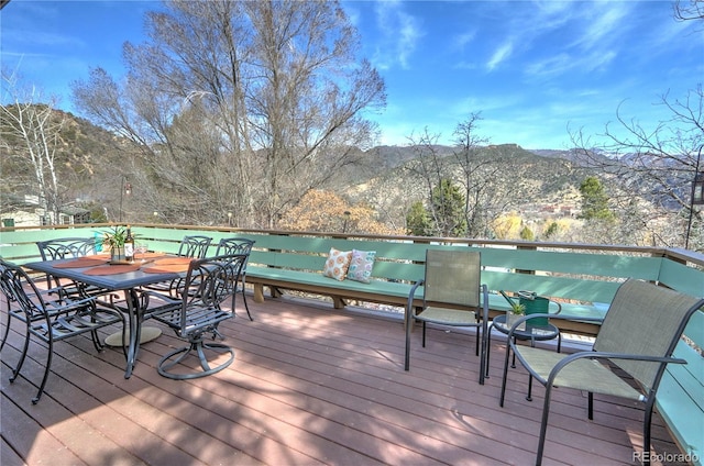 wooden deck featuring a mountain view and outdoor dining area