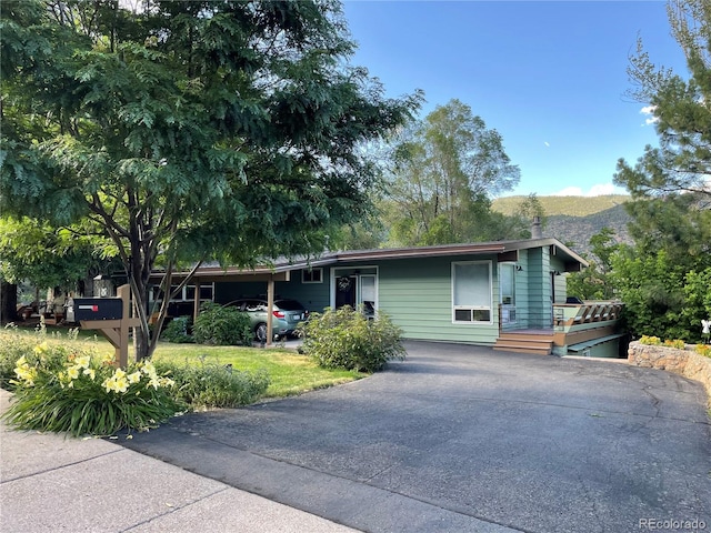 611 W 12th St, Glenwood Springs, CO 81601 - view of front of house featuring driveway, a deck with mountain view, and an attached carport