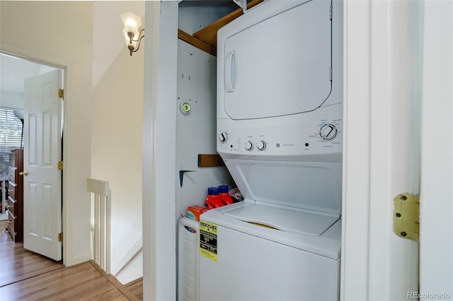 laundry area featuring stacked washer / dryer and light hardwood / wood-style floors