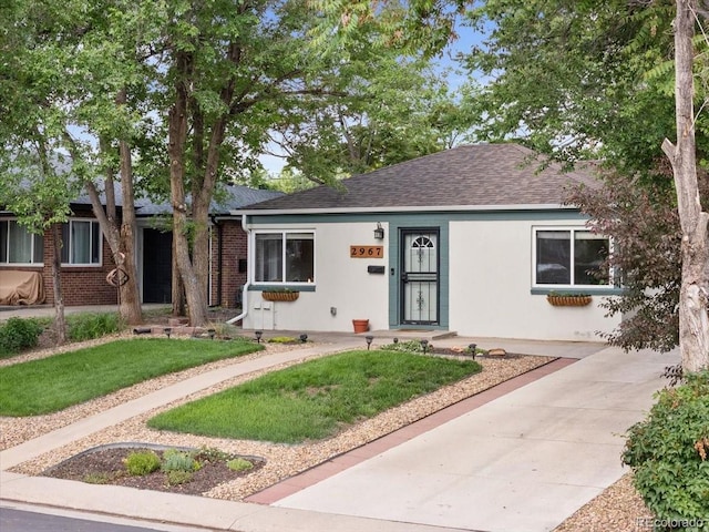 2967 Olive St, Denver, CO 80207 - view of front of property featuring stucco siding, a shingled roof, and a front lawn