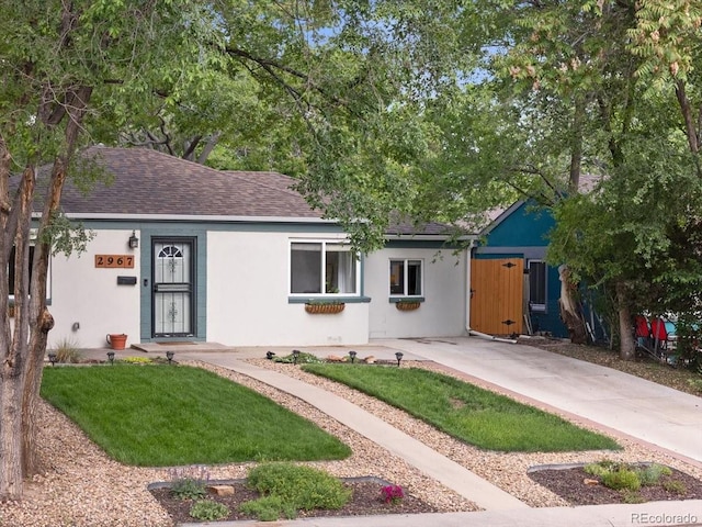2967 Olive St, Denver, CO 80207 - ranch-style house featuring stucco siding, a shingled roof, and a front yard