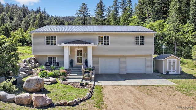 20854 State Highway 96, Wetmore, CO 81253 - raised ranch with dirt driveway, a storage shed, an attached garage, a metal roof, and a forest view